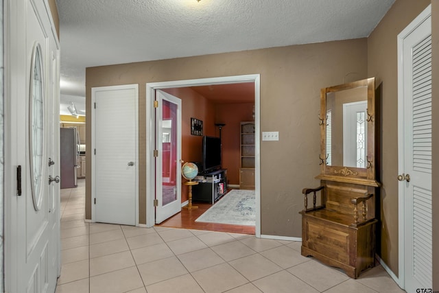 256 Ox Bow Cv, Holly Lake Ranch, TX 75765 - corridor featuring a textured ceiling, light tile patterned floors, and baseboards