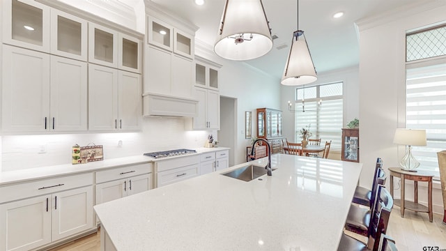 9070 Shallow Cv, Tyler, TX 75703 - kitchen featuring a breakfast bar area, white cabinetry, a center island with sink, decorative backsplash, and recessed lighting