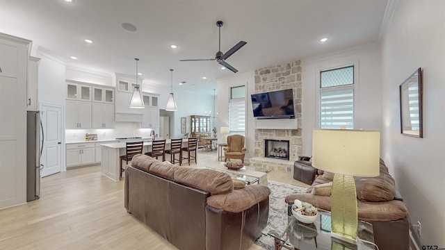 9070 Shallow Cv, Tyler, TX 75703 - living area featuring ornamental molding, plenty of natural light, a ceiling fan, light wood-style flooring, and a fireplace