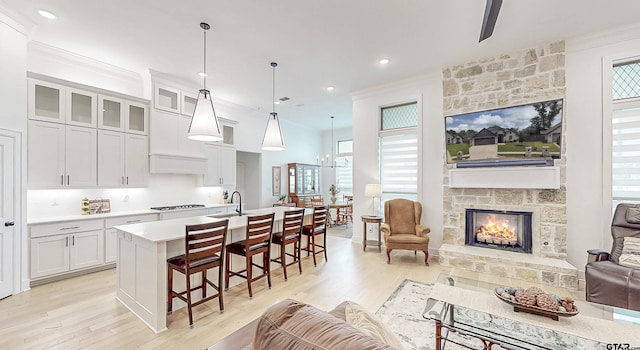9070 Shallow Cv, Tyler, TX 75703 - kitchen with open floor plan, crown molding, light countertops, light wood finished floors, and an island with sink