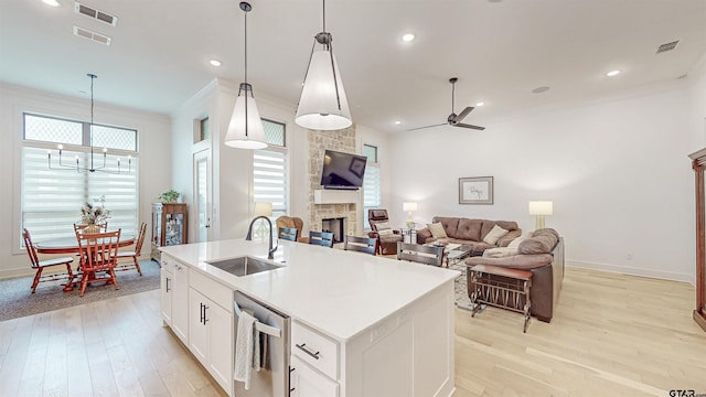 9070 Shallow Cv, Tyler, TX 75703 - kitchen with a stone fireplace, light wood-type flooring, a chandelier, dishwasher, and ceiling fan