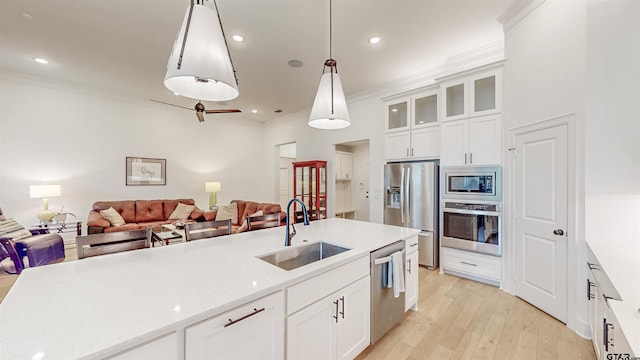 9070 Shallow Cv, Tyler, TX 75703 - kitchen with open floor plan, crown molding, stainless steel appliances, white cabinets, and light wood finished floors