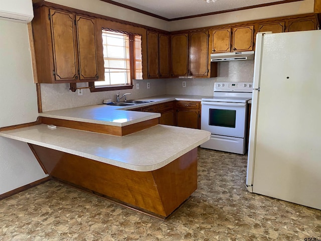 kitchen featuring white appliances, brown cabinets, a peninsula, under cabinet range hood, and a sink