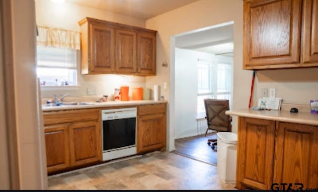 209 Kildare Rd, Linden, TX 75563 - kitchen with light floors, light countertops, dishwashing machine, a sink, and brown cabinetry