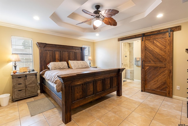 bedroom with connected bathroom, ornamental molding, ceiling fan, a raised ceiling, and a barn door