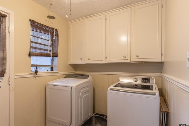 washroom with cabinets, separate washer and dryer, and a textured ceiling