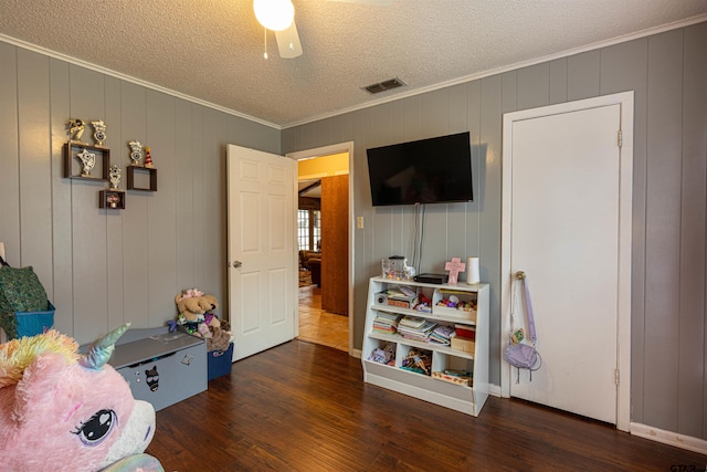 playroom featuring ornamental molding, dark hardwood / wood-style floors, and a textured ceiling