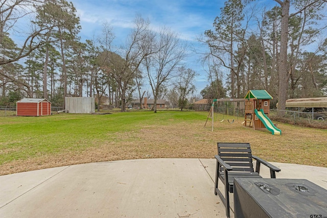 view of yard with a patio area, a playground, and a storage unit