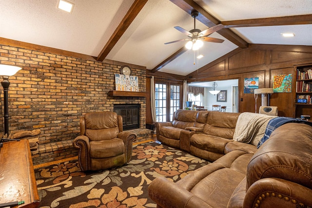 living room featuring vaulted ceiling with beams, a brick fireplace, a textured ceiling, ceiling fan, and brick wall