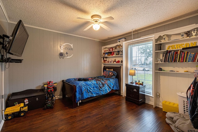 bedroom with ornamental molding, ceiling fan, a textured ceiling, and dark hardwood / wood-style flooring