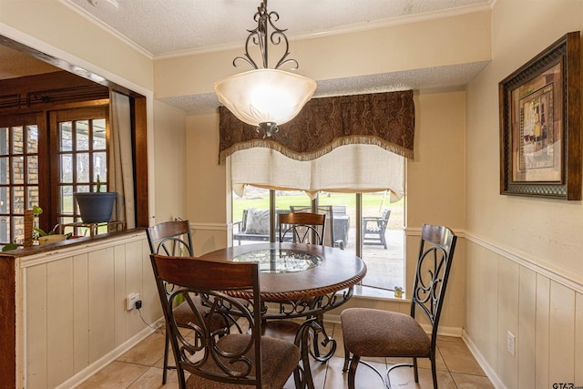 dining space with light tile patterned floors, a wealth of natural light, and a textured ceiling