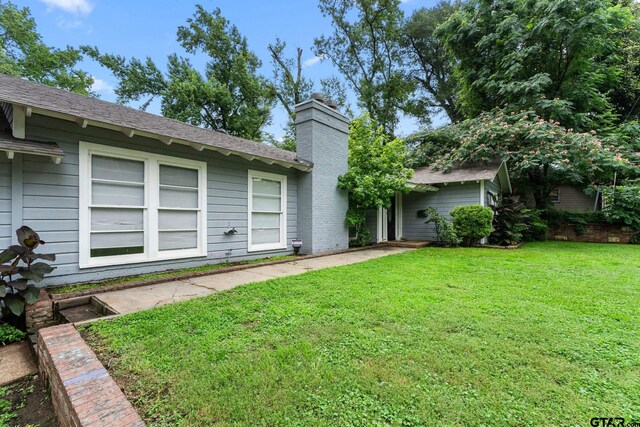 708 E Loftin St, Tyler, TX 75701 - view of front of home with a chimney, a front lawn, and a shingled roof