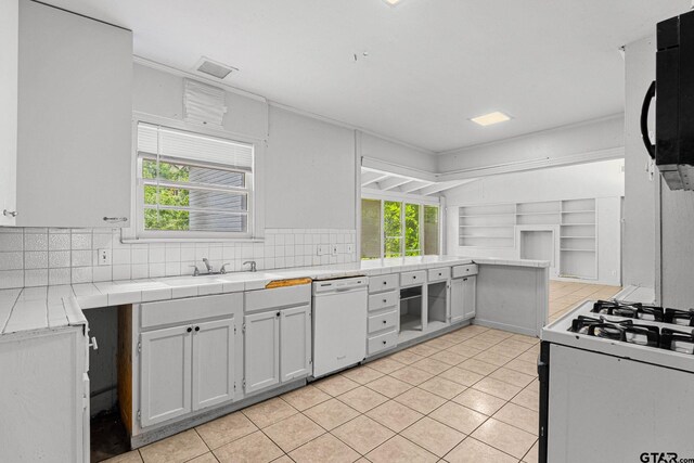 708 E Loftin St, Tyler, TX 75701 - kitchen featuring white appliances, decorative backsplash, healthy amount of natural light, and light tile patterned flooring