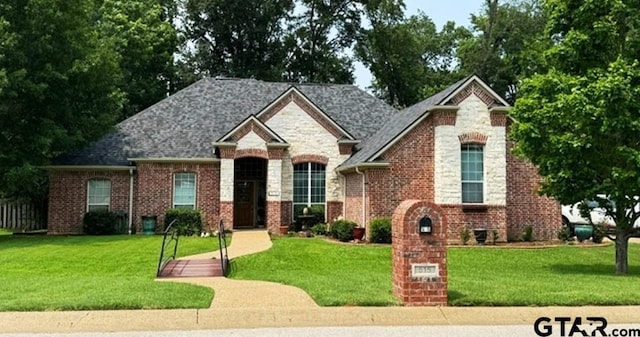view of front of house with stone siding, a front lawn, and brick siding