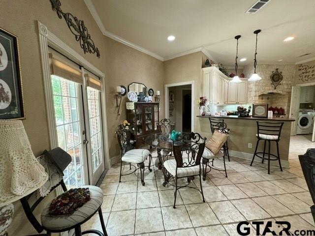 dining space with washer / dryer, visible vents, light tile patterned flooring, and french doors