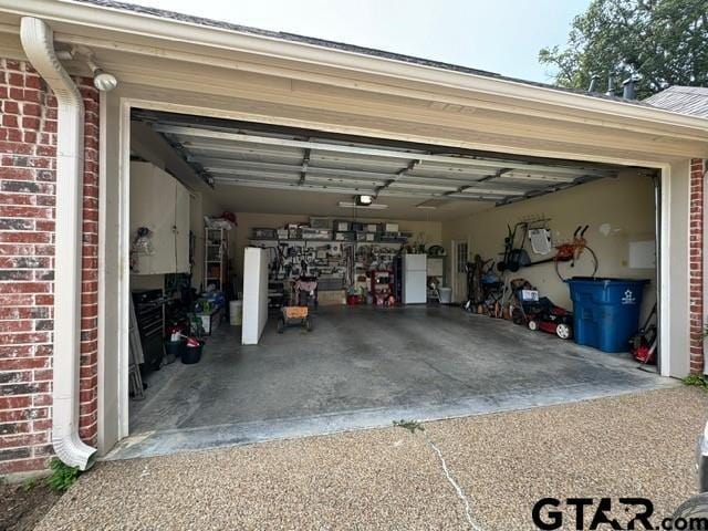 garage with driveway and a garage door opener