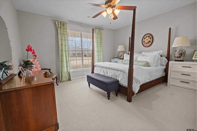 bedroom with arched walkways, light colored carpet, and ceiling fan