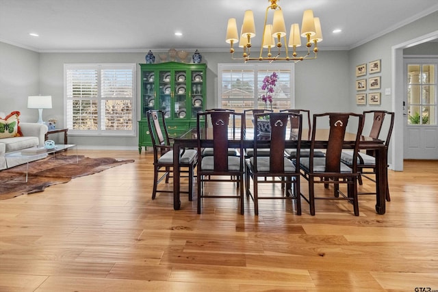 dining room with light wood-style flooring, crown molding, and a wealth of natural light