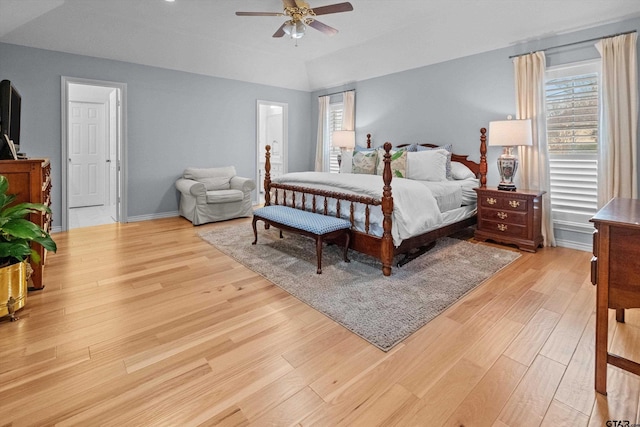 bedroom with light wood-type flooring, ceiling fan, lofted ceiling, and baseboards