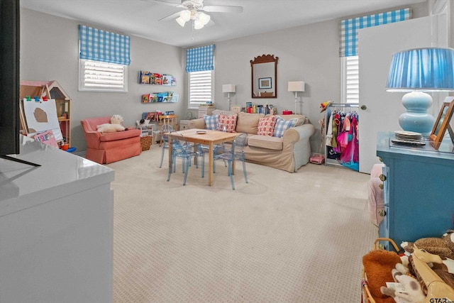 recreation room with a ceiling fan and light colored carpet