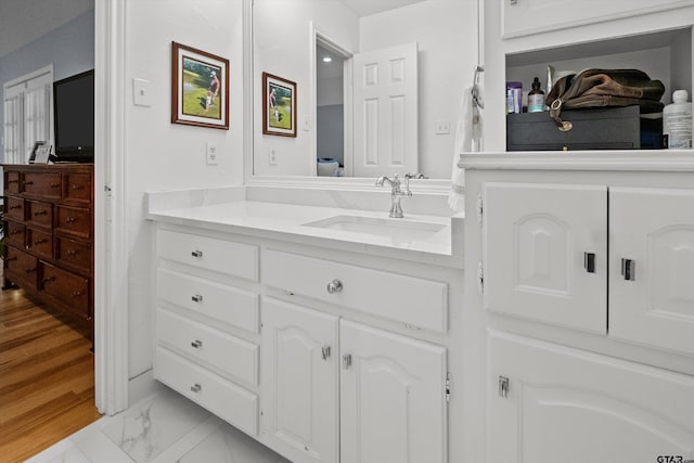 bathroom with marble finish floor and vanity