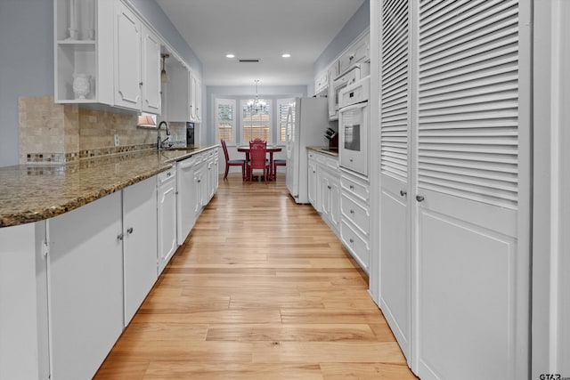 kitchen featuring white cabinets, open shelves, and a sink