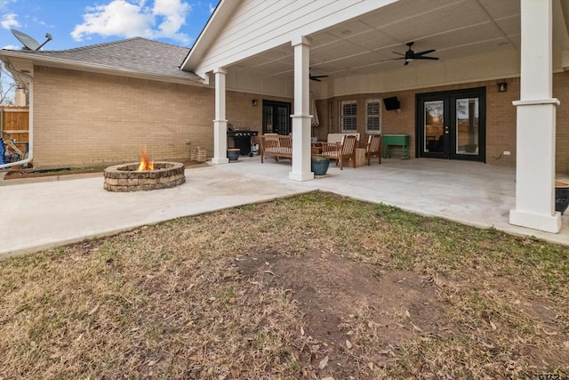 view of patio / terrace with french doors, an outdoor fire pit, and a ceiling fan