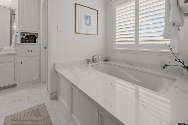 full bathroom with marble finish floor, a bathing tub, and vanity