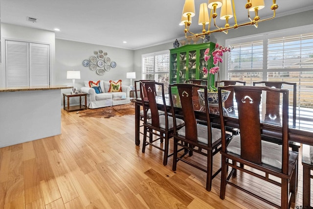 dining room with visible vents, light wood-style flooring, ornamental molding, a chandelier, and recessed lighting