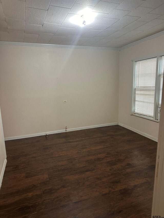 unfurnished room featuring dark wood-type flooring and ornamental molding