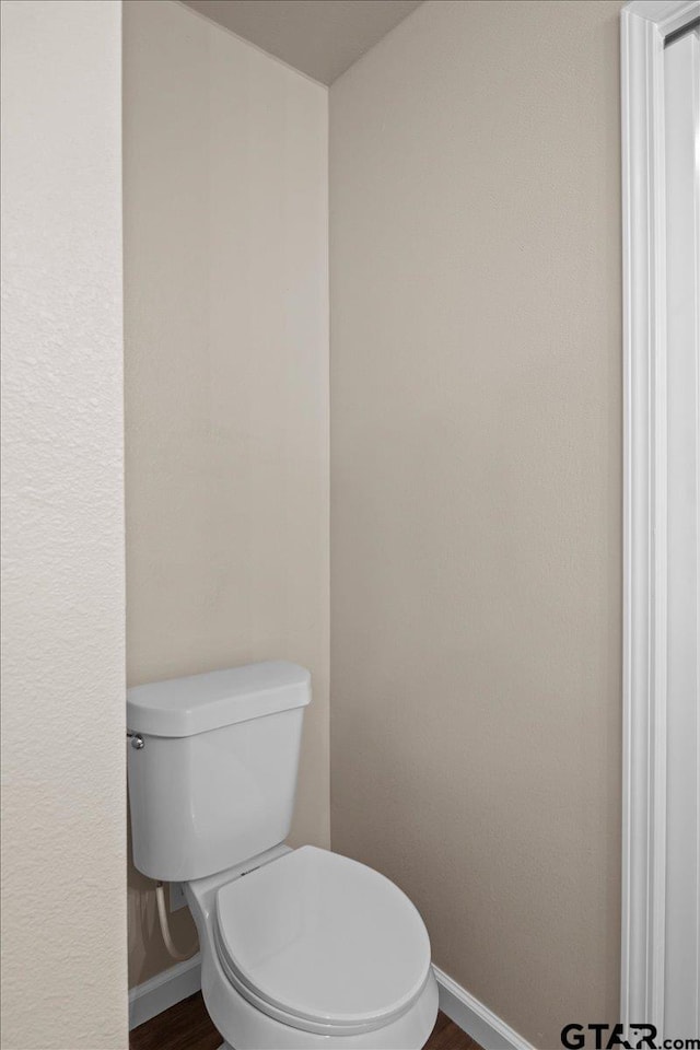 bathroom featuring hardwood / wood-style floors and toilet