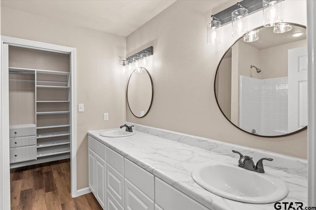 bathroom with wood-type flooring, vanity, and a shower