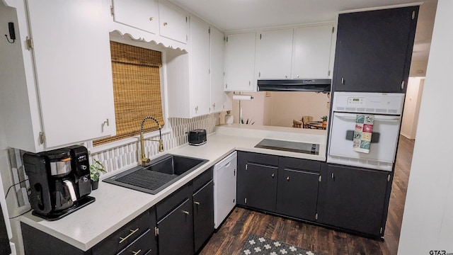 1418 E Dawson St, Tyler, TX 75701 - kitchen with white appliances, under cabinet range hood, dark wood-style flooring, and light countertops
