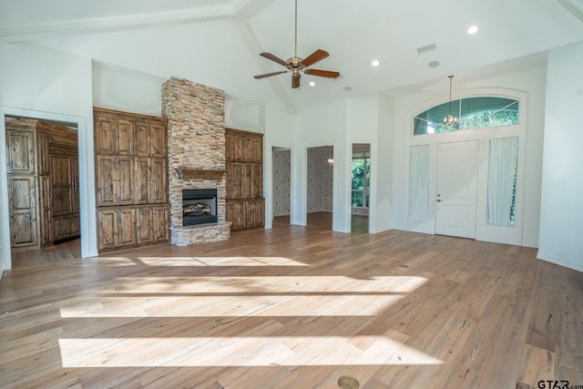 21585 Syrah Ln, Tyler, TX 75703 - unfurnished living room featuring high vaulted ceiling, a fireplace, light wood finished floors, beamed ceiling, and a ceiling fan