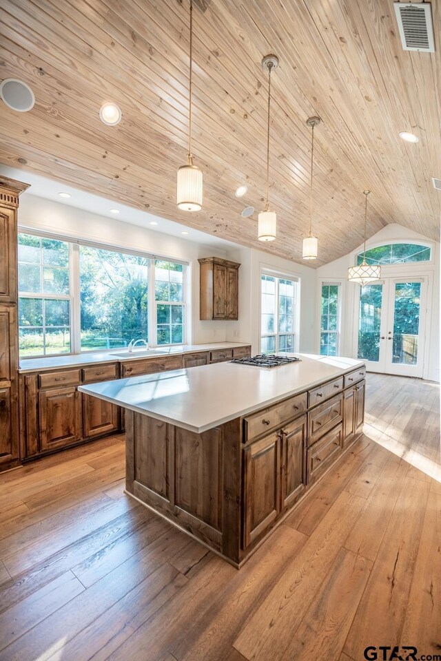 21585 Syrah Ln, Tyler, TX 75703 - kitchen featuring a center island, wooden ceiling, light wood-style floors, french doors, and light countertops