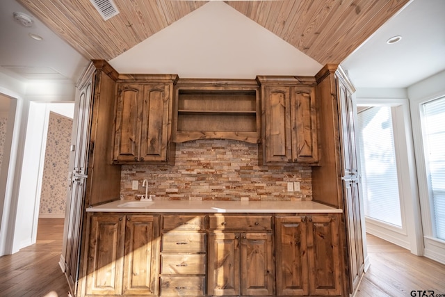 bar featuring decorative backsplash, vaulted ceiling, wooden ceiling, and light hardwood / wood-style flooring