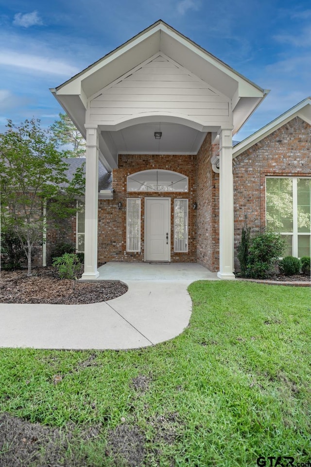 21585 Syrah Ln, Tyler, TX 75703 - view of exterior entry with a yard and brick siding