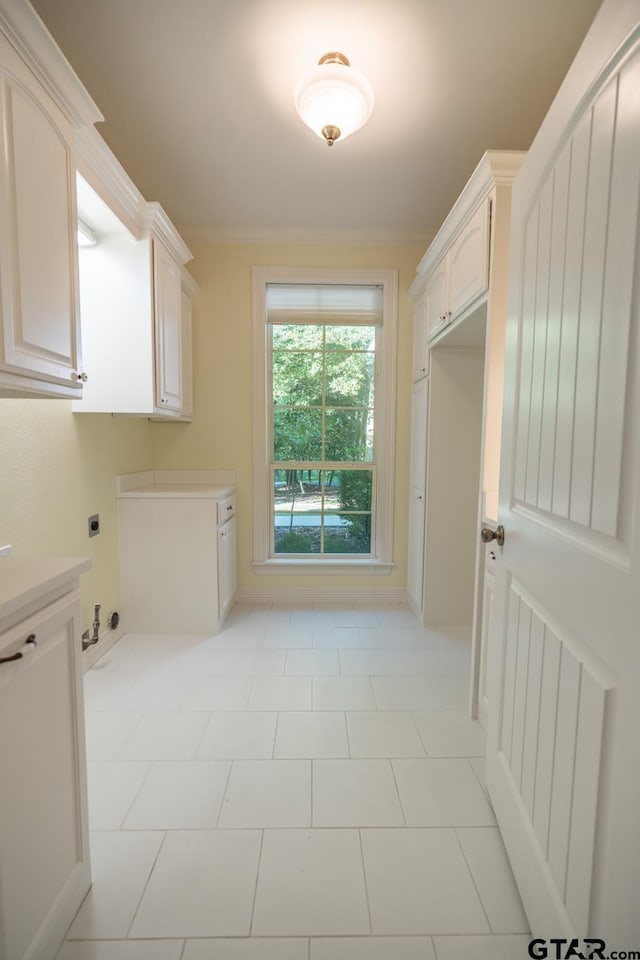 clothes washing area with cabinets, light tile patterned floors, and hookup for an electric dryer