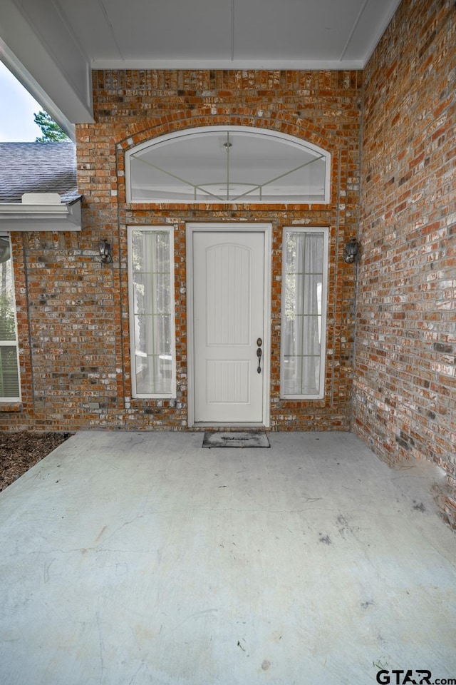 view of exterior entry with a patio