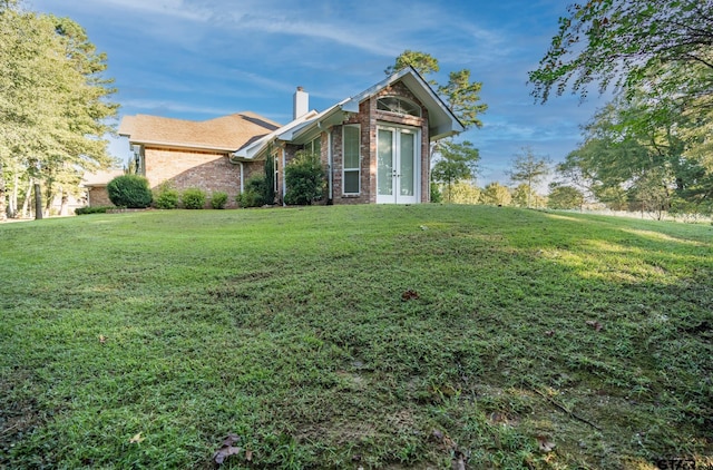 21585 Syrah Ln, Tyler, TX 75703 - view of side of home featuring french doors, brick siding, a chimney, and a yard