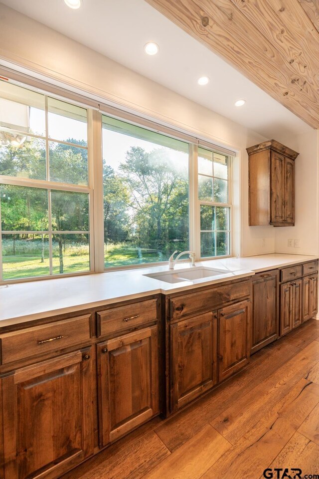 21585 Syrah Ln, Tyler, TX 75703 - kitchen with a sink, wood-type flooring, light countertops, recessed lighting, and brown cabinetry
