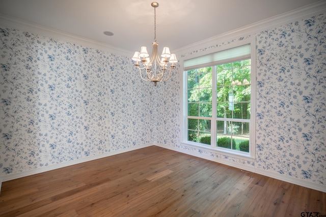 spare room with ornamental molding, hardwood / wood-style flooring, and a chandelier