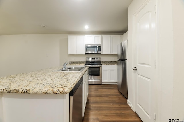 807 W Morris St, Tyler, TX 75702 - kitchen with stainless steel appliances, dark wood-style flooring, white cabinets, light stone counters, and an island with sink