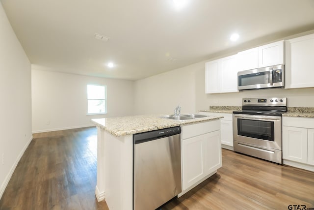 807 W Morris St, Tyler, TX 75702 - kitchen featuring appliances with stainless steel finishes, wood finished floors, an island with sink, white cabinetry, and recessed lighting