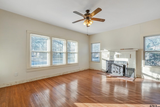 unfurnished living room featuring hardwood / wood-style flooring, a healthy amount of sunlight, and ceiling fan