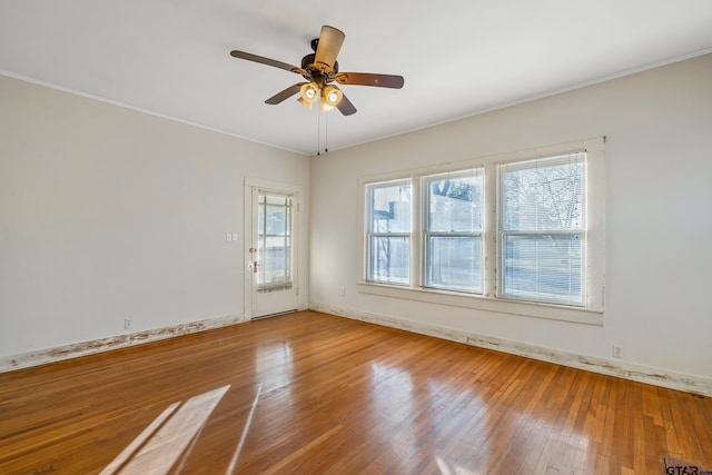 empty room featuring hardwood / wood-style flooring, ceiling fan, and a healthy amount of sunlight