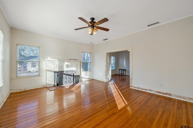 unfurnished living room with ornamental molding, hardwood / wood-style floors, and a wealth of natural light