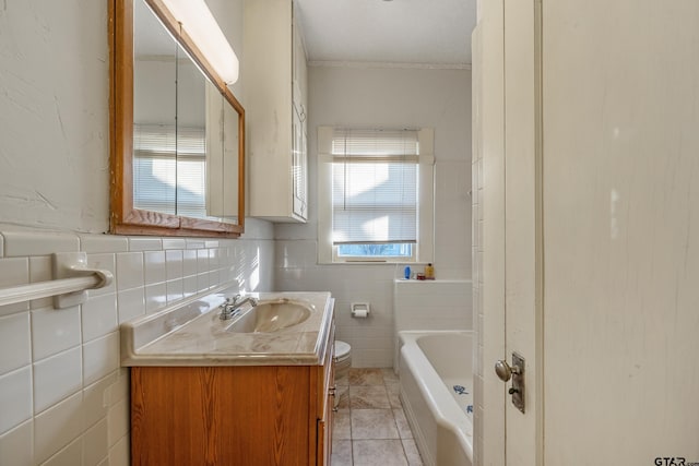 bathroom with tile patterned flooring, vanity, a bath, and tile walls