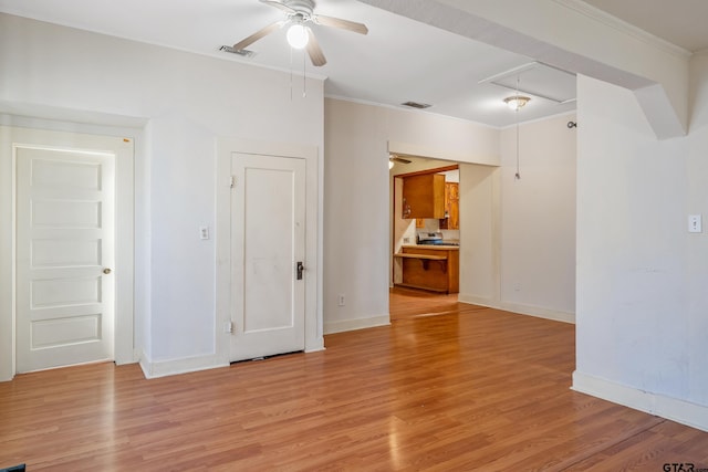 empty room featuring ornamental molding and light hardwood / wood-style flooring