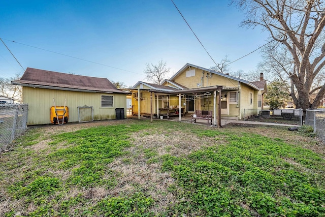 rear view of house with a patio and a lawn